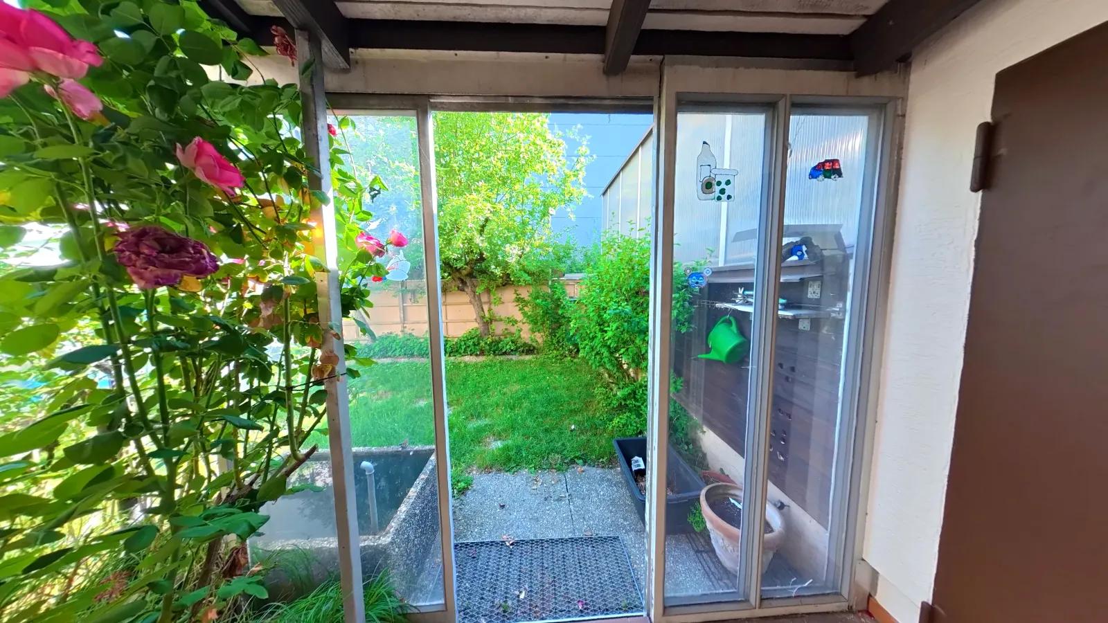 Still frame from the holiday flat tour: conservatory looking out into the garden